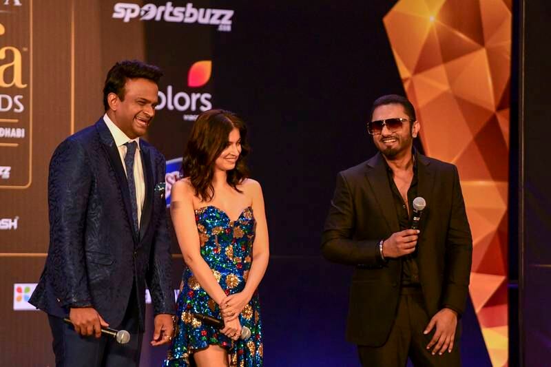 Siddharth Kanan, Indian TV host laughs on stage with Divya Khosla Kumar and Yo Yo Honey Singh.