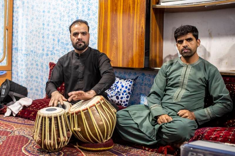 Ashraf Omary (L) plays the drum that he kept hidden in his basement next to his musical instructor brother, Heshmat.