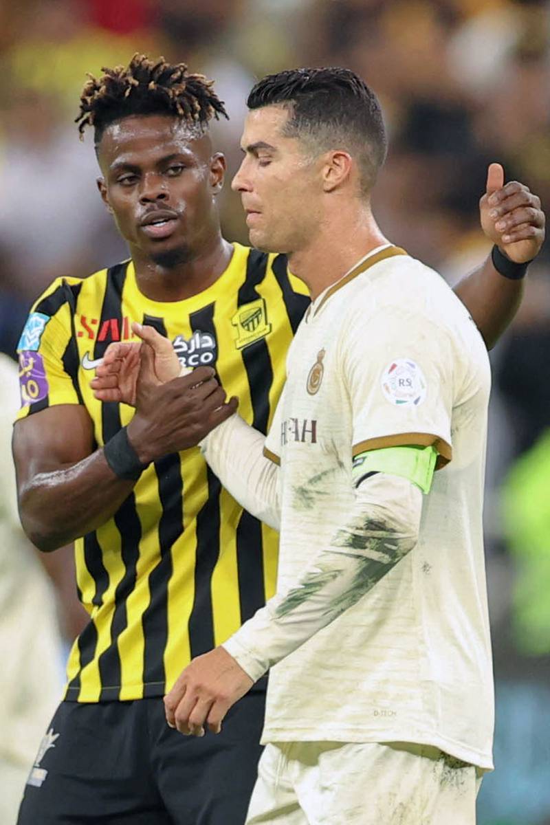 Ittihad's Saudi defender Zakaria Hawsawi shakes hands with Cristiano Ronaldo. AFP