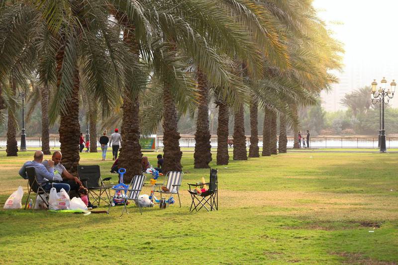 KYW2FT SHARJAH, UAE - DECEMBER 10, 2017: People visit Al Nakheel Oasis park with palm trees in Sharjah, UAE. This third populous city of UAE is the capital o