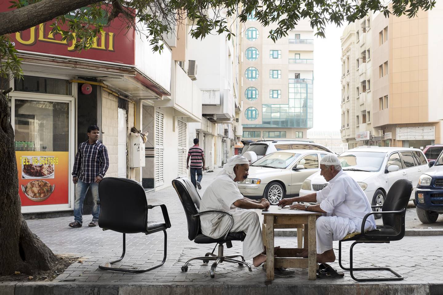 SHARJAH, UNITED ARAB EMIRATES, MAY 6, 2015. Two men play dominoes on the street in Al Nabba in Sharjah.
 Photo: Reem Mohammed / The National *** Local Caption ***  RM_20150406_SHJ_32.JPGRM_20150406_SHJ_32.JPG