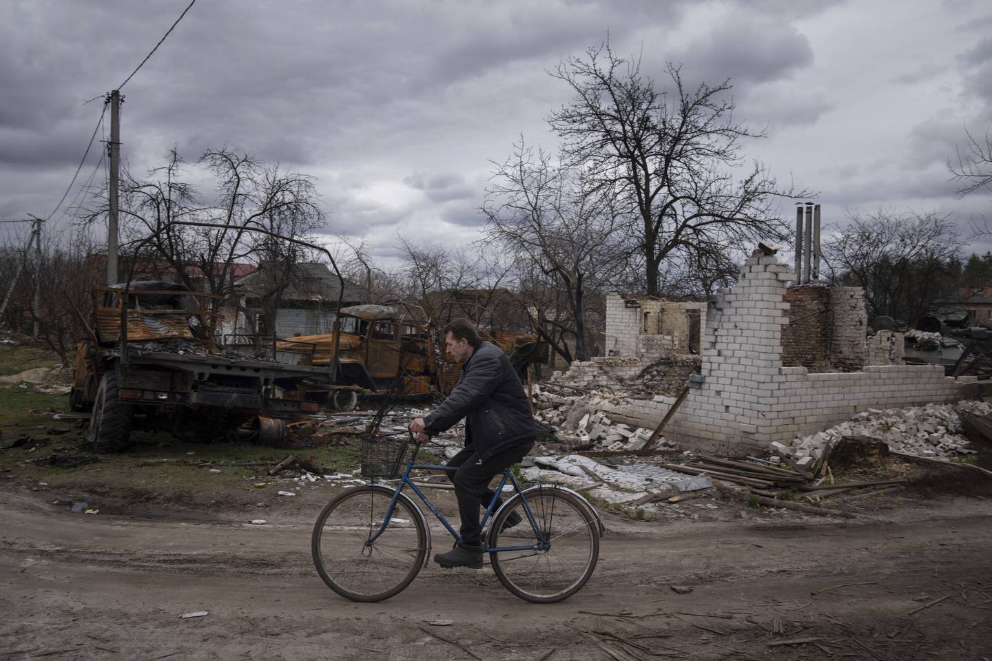 Destroyed vehicles and a building in Yahidne, Ukraine.  PA