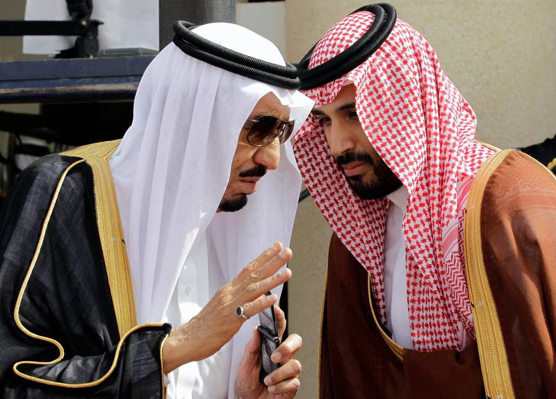 FILE - In this May 14, 2012 file photo, then-Crown Prince Salman, left, speaks with his son, Prince Mohammed  in Riyadh, Saudi Arabia. Saudi Arabia under King Salman and Crown Prince Mohammed bin Salman has replaced its military chief of staff and other defense officials amid its stalemated war in Yemen early Tuesday, Feb. 27, 2018. (AP Photo/Hassan Ammar, File)