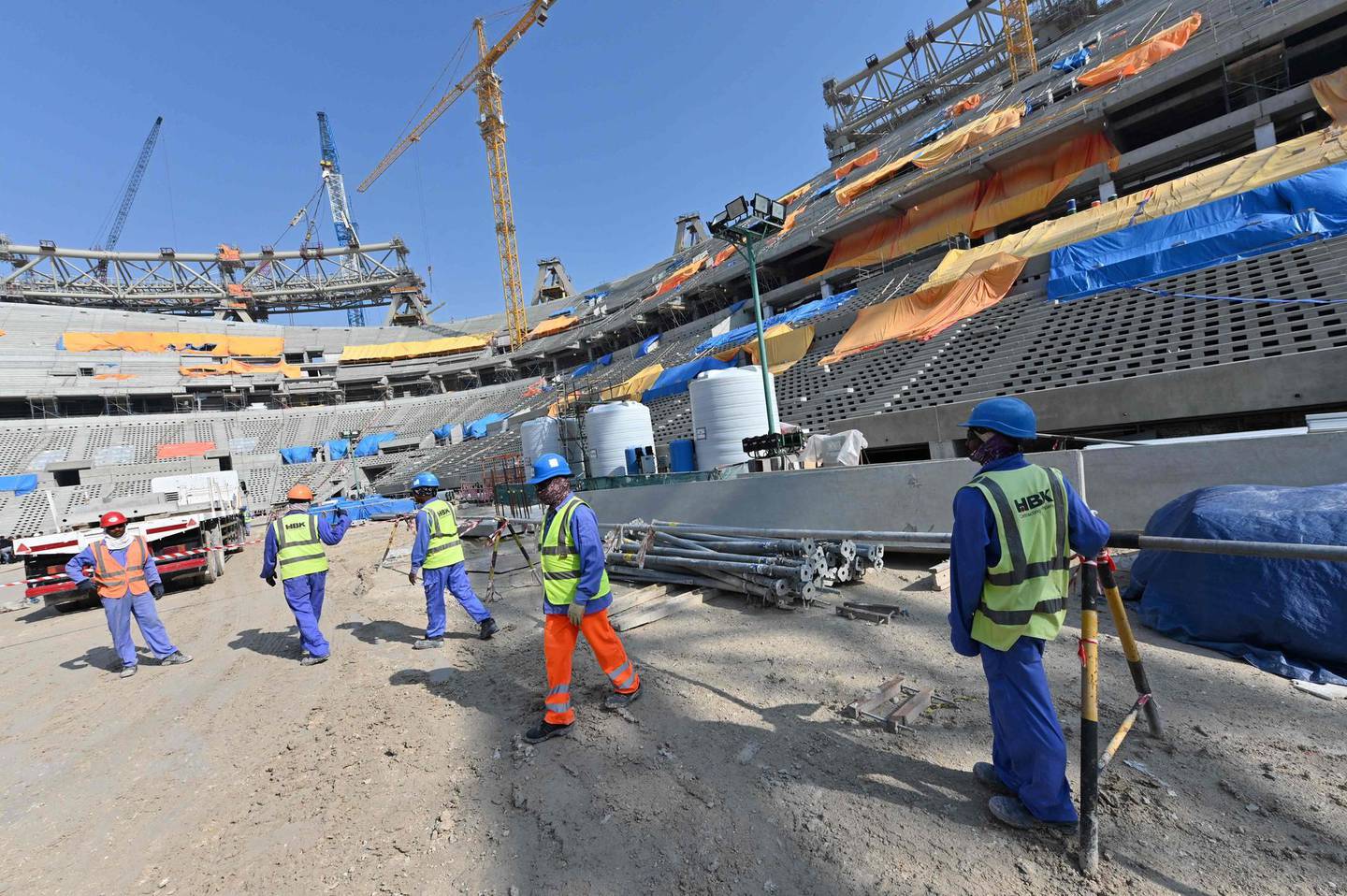 (FILES) This file photo taken on December 20, 2019 shows construction workers at Qatar's Lusail Stadium, around 20 kilometres north of the capital Doha. An extraordinary congress of the Norwegian Football Federation to be held on June 20, 2021 plans to vote on a potential boycott of the upcoming World Cup in Qatar.
 / AFP / GIUSEPPE CACACE
