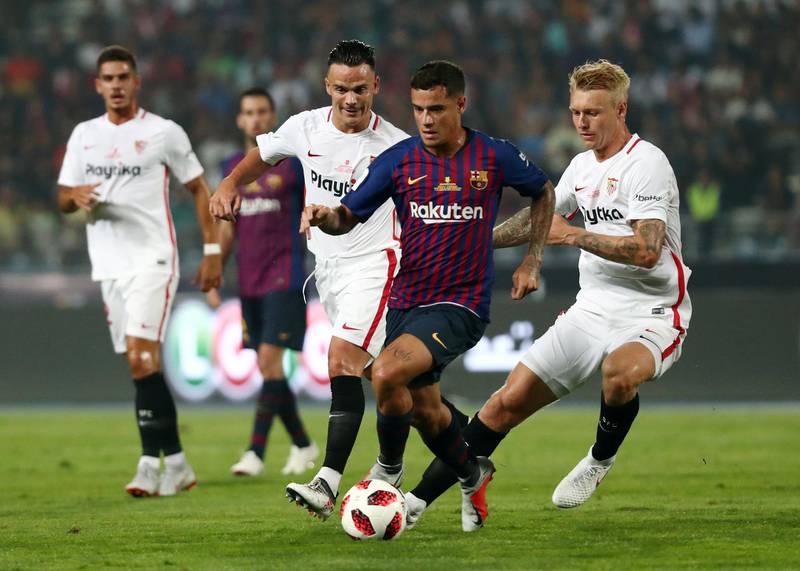 Barcelona's Philippe Coutinho in action with Sevilla's Simon Kjaer and Roque Mesa. Reuters