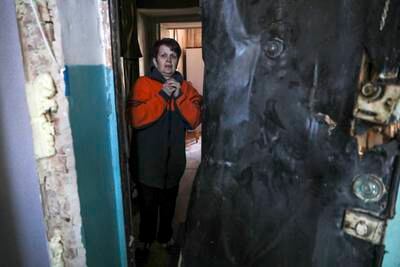 A woman stands in her home after her building was damaged by shelling in Kyiv. EPA