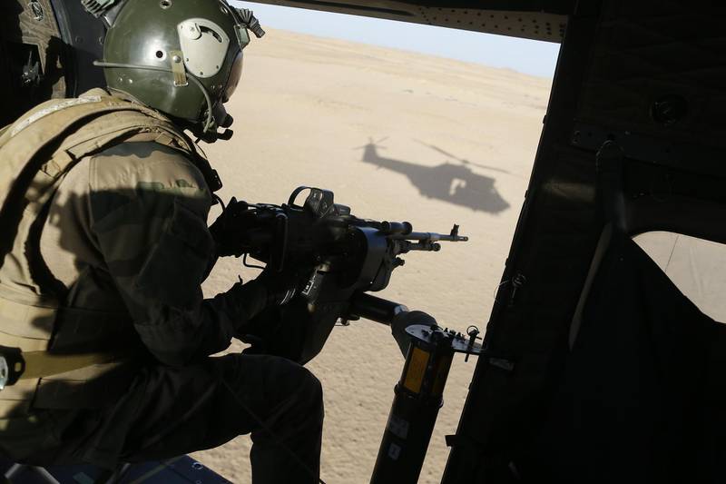 (FILES) In this file photo taken on March 17, 2013 A French gunner sits in a Puma helicopter flying near Tessalit. A French corporal was killed tracking down jihadist fighters in their northern Mali mountain bastions, bringing to five the number of French deaths since Paris launched a military offensive in the country two months ago. Defence Minister Jean-Yves Le Drian said on March 17, 2013 the 24-year-old soldier was killed and three of his comrades wounded when their vehicle was struck by a roadside bomb blast in the Ifoghas mountains, without saying when it happened.   Thirteen soldiers from France's anti-terrorist Barkhane force in Mali were killed after two helicopters collided during an operation in the country's north, the French presidency said on November 26, 2019.
The accident occurred on November 25, 2019, while the forces were engaging jihadist fighters who have staged a series of deadly strikes in northern Mali in recent weeks, the Elysee Palace said.

 / AFP / Kenzo TRIBOUILLARD

