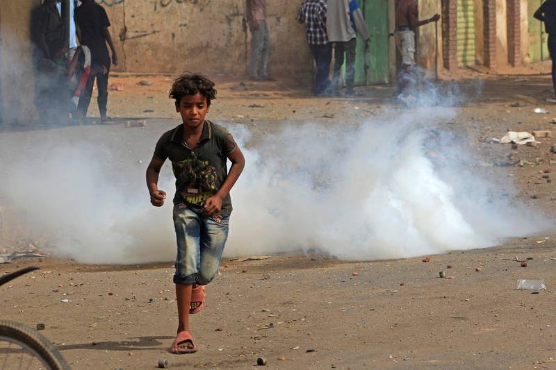 A Sudanese boy flees tear gas fired by security forces during a demonstration against military rule in Khartoum on June 30, 2022. AFP