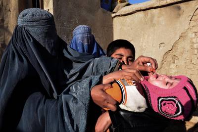 An Afghan health worker administers the polio vaccine to a child  in Kandahar. Javed Tanveer / AFP Photo
