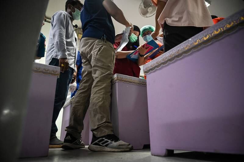 Rescue workers inspect coffins containing the bodies of victims at a hospital in Udon Thani, Thailand. Getty Images