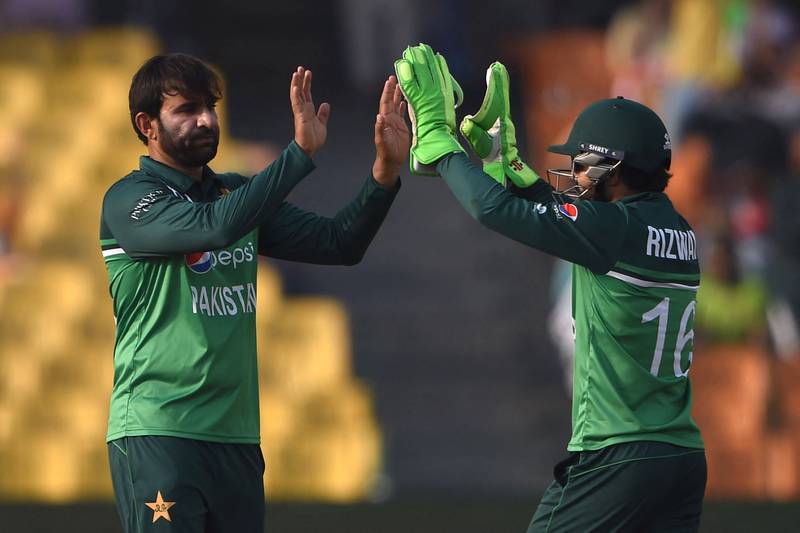 Pakistan's Iftikhar Ahmed, left, celebrates with wicketkeeper Mohammad Rizwan after taking the wicket of Australia's Travis Head. AFP