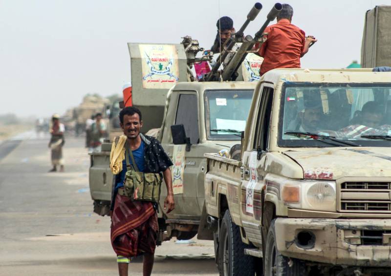 Yemeni fighters from the Amalqa ("Giants") Brigades, loyal to the Saudi-backed government, gather with armed pick-up trucks and armoured vehicles on the side of a road during the offensive to seize the Red Sea port city of Hodeidah from Iran-backed Houthi rebels, on its southern outskirts near the airport on June 21, 2018. Saleh Al-Obeidi / AFP