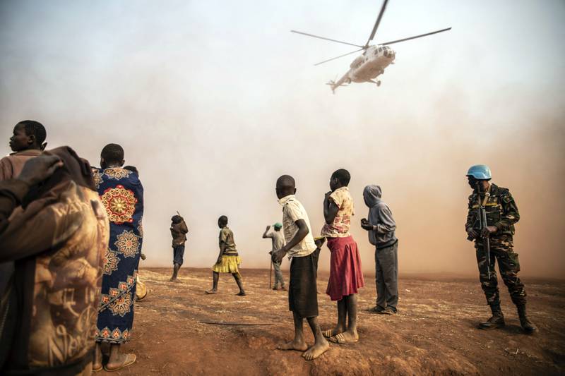 Displaced people watch the  UN helicopter carrying Under-Secretary-General for Peace Operations Jean Pierre Lacroix land in Bunia, Democratic Republic of the Congo. AP