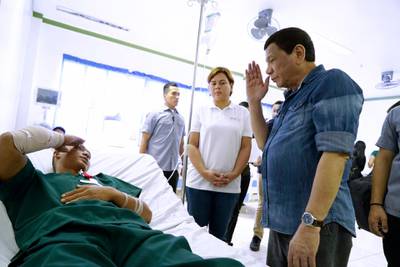 Rodrigo Duterte saluting a soldier wounded by an explosion, during a visit to a military camp in Jolo, Sulu province, southern Philippines. Twin bombings hit a Sunday mass at Jolo Cathedral in the Mindanao region of the southern Philippines on January 27.  EPA
