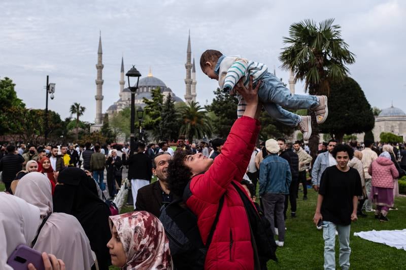 A child is held aloft amid Eid celebrations outside the mosque. Getty 