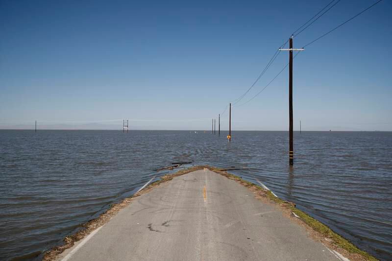 Water engulfs a road in Helm Corner, California. EPA
