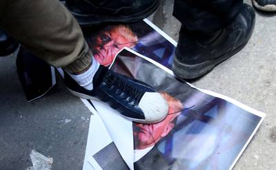 Palestinian protesters tread on a picture of US president Donald Trump  during a protest  in the West Bank City of Nablus on December 7, 2017. Alaa Badarneh / AFP
