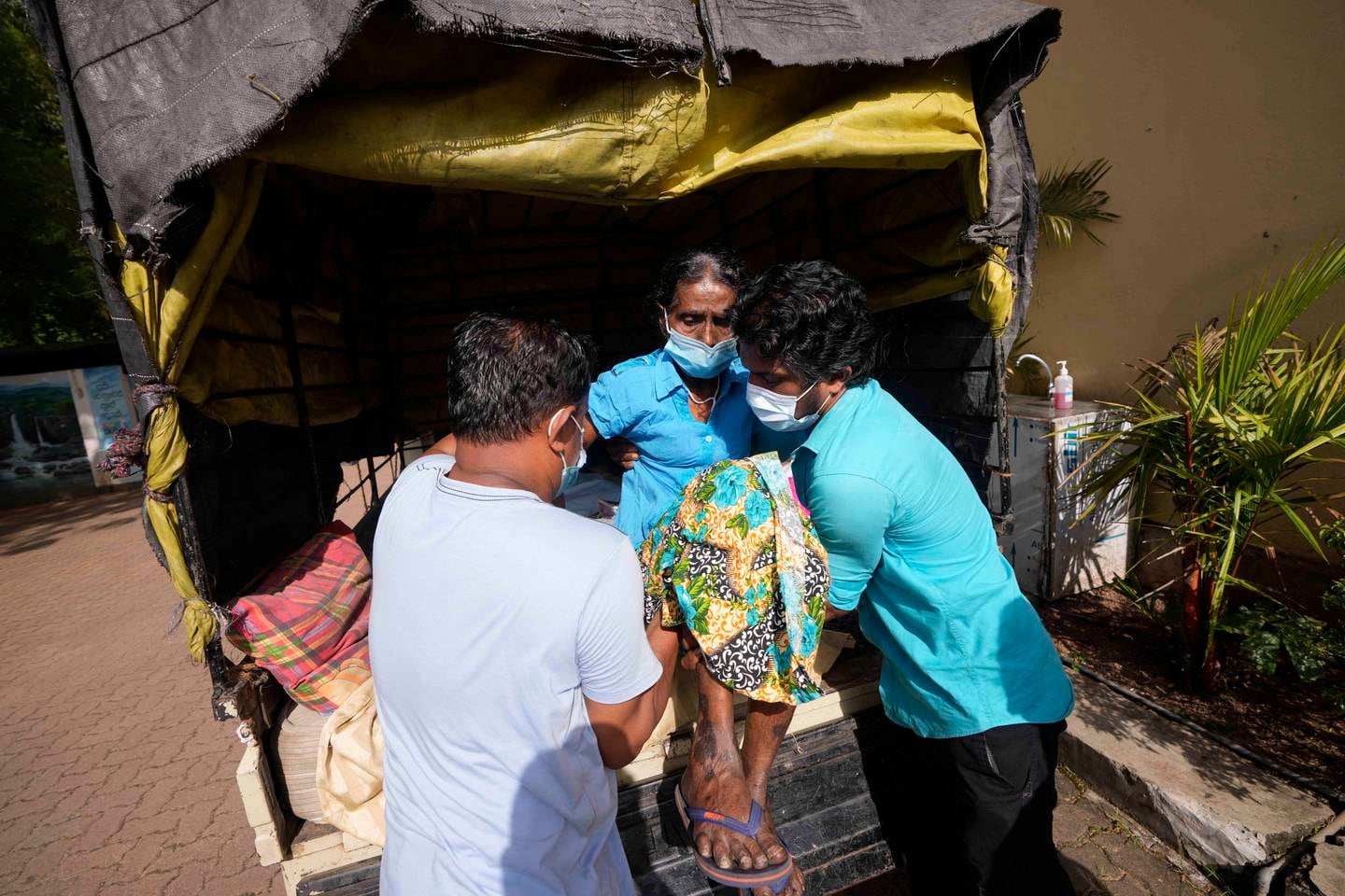 A patient is helped on to a vehicle by relatives as she sets out for her village after attending a clinic at the national cancer hospital in Maharagama, a suburb of Colombo, Sri Lanka. AP Photo 