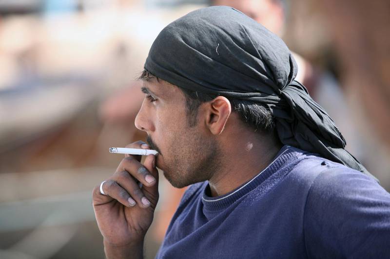 DUBAI, UNITED ARAB EMIRATES - DECEMBER 10:  A man smoking outdoors at the Deira Creek in Dubai on December 10, 2008.  (Randi Sokoloff / The National) For Stock.   *** Local Caption ***  RS003-1210-SMOKING.jpgRS003-1210-SMOKING.jpg