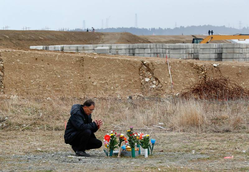 A man offers a prayer for victims at post office in Ukedo district, Namie, Fukushima Prefecture, Japan, on March 11, 2018. Kimimasa Mayama / EPA