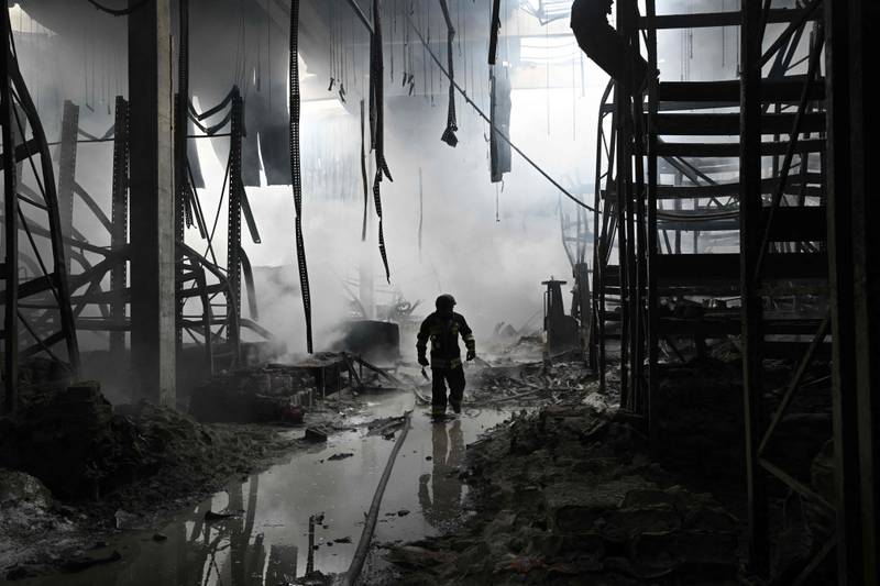 A Ukrainian firefighter walks amid rubble in a shopping mall following a Russian shelling in Kherson. AFP
