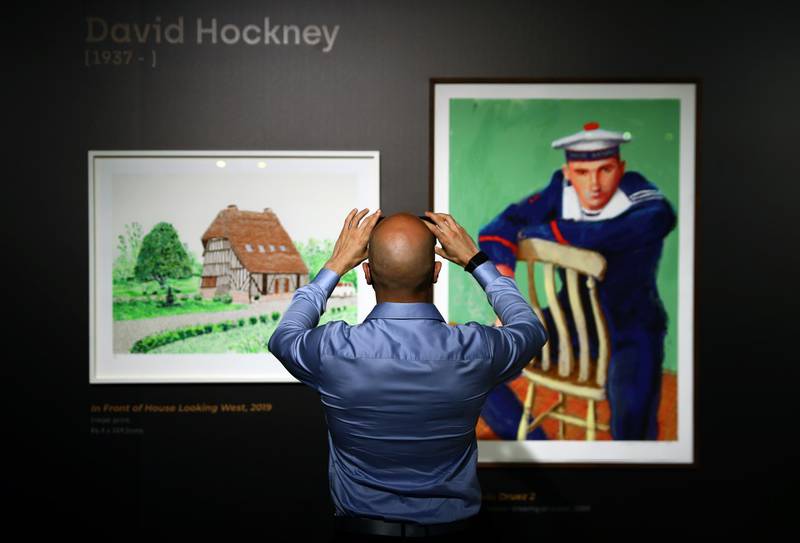 DUBAI, UNITED ARAB EMIRATES - APRIL 24: A man takes a picture of art work by David Hockney  during the Mohammed Bin Rashid Al Maktoum's 100 Million Meals Campaign at Mandarin Oriental Jumeirah  on April 24, 2021 in Dubai, United Arab Emirates. Works by artists including Picasso, Hockney, Miro and Matisse will be auctioned at a private event to raise money in the Mohammed Bin Rashid Al Maktoum's 100 Million Meals Campaign to end hunger during the Muslim holy month of Ramadan. (Photo by Francois Nel/Getty Images)
