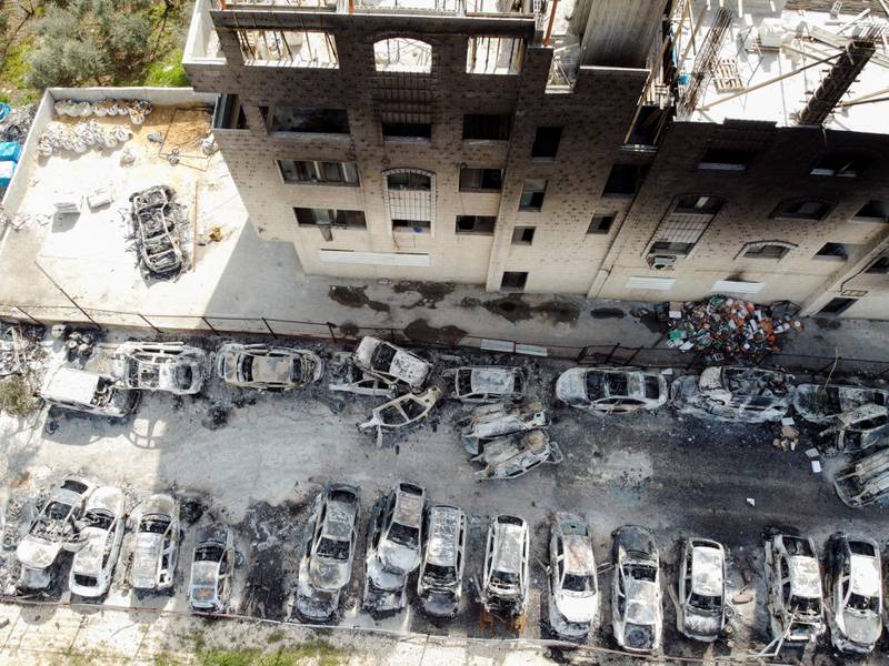 An aerial view shows a building and cars torched in Hawara. Reuters
