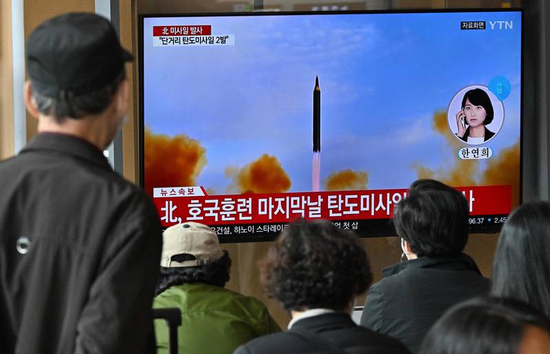 People watch a news broadcast with file footage of a North Korean missile test, at a railway station in Seoul on October 28, 2022. North Korea fired two short-range ballistic missiles, according to South Korea's military. AFP