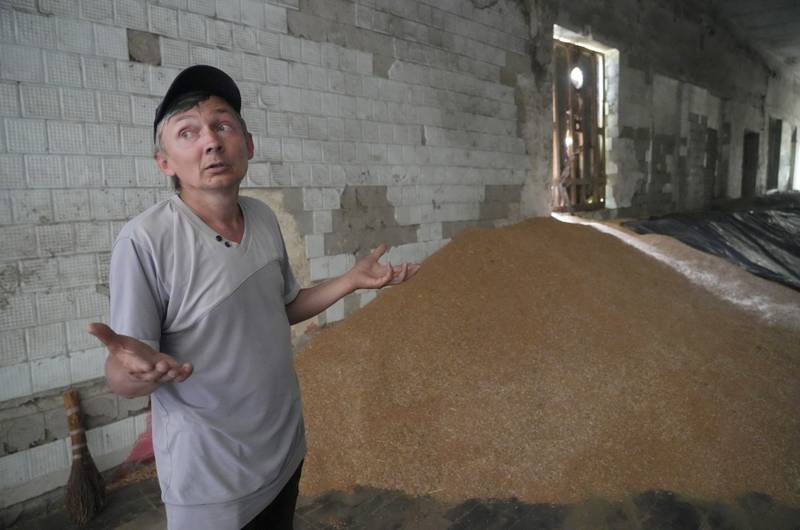 Serhiy shows a mound of grain in his barn. AP