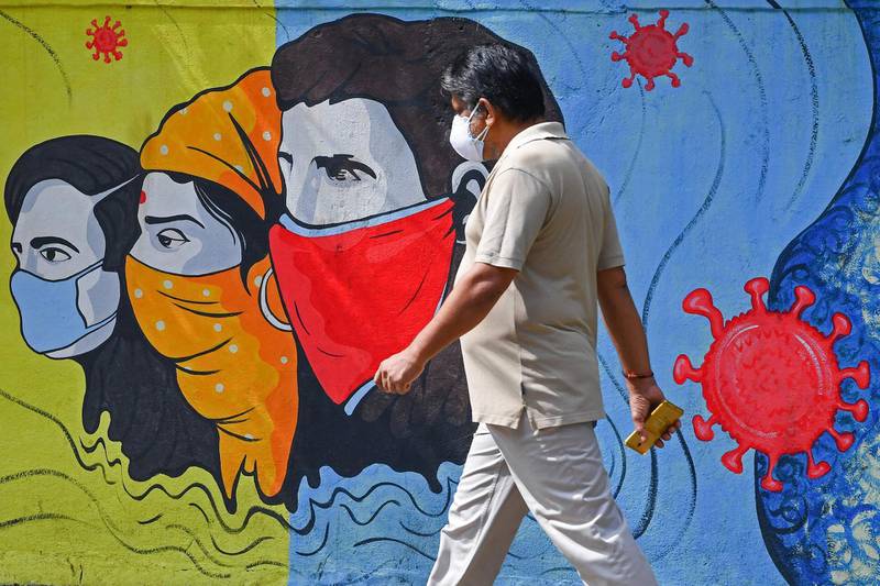 A pedestrian walks past a mural representing awareness measures against Covid-19 in Navi Mumbai.