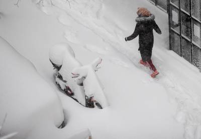 A woman walks along a street after a heavy snowfall in Madrid, Spain. AP Photo
