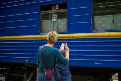 Diana, on the train, waves to her mother Viktoriya and sister Kseniya as she leaves Pokrovsk in eastern Ukraine. AP