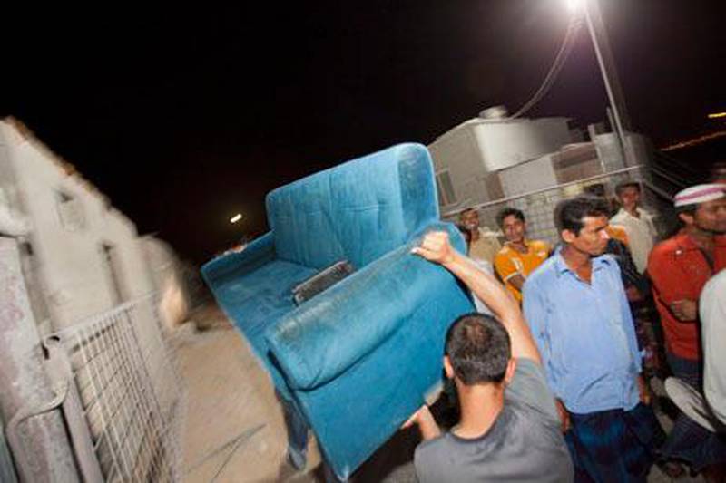 UAE - Ajman - May 17- 2011:   Workers carry a couch in to  Abou Seif labour camp.. Take My Junk, an organisation that collects people's unwanted stuff gives it to labourers. ( Jaime Puebla - The National Newspaper )