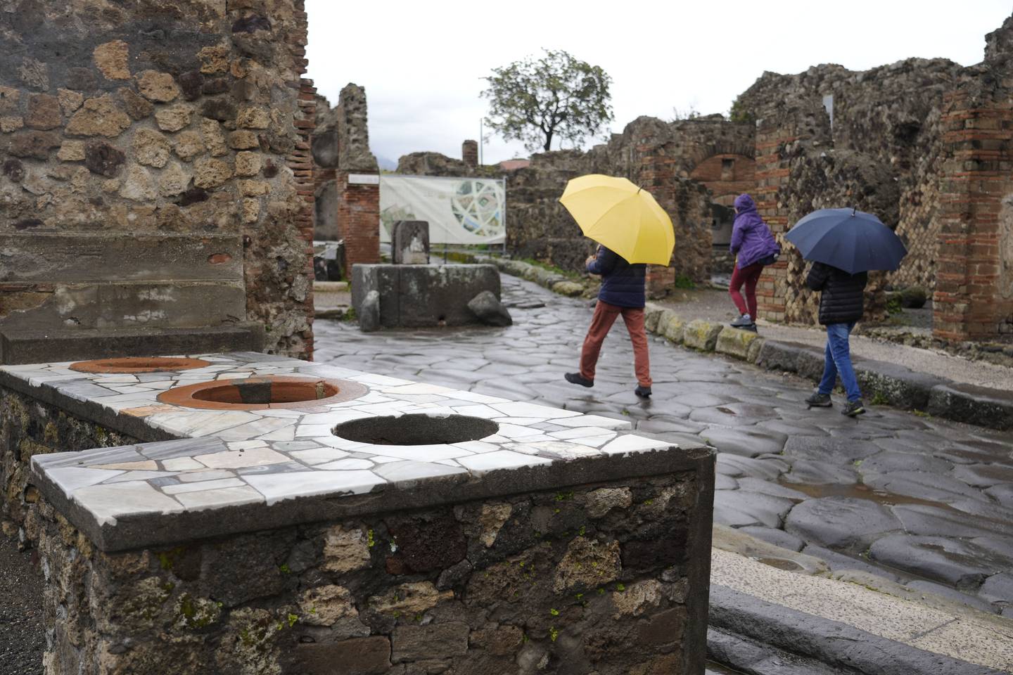 Des touristes passent devant un thermopolium à Pompéi.  AP Photo