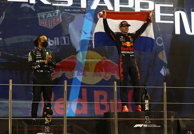 Verstappen drinks in the moment as Mercedes driver Lewis Hamilton looks dejected after finishing second. Reuters