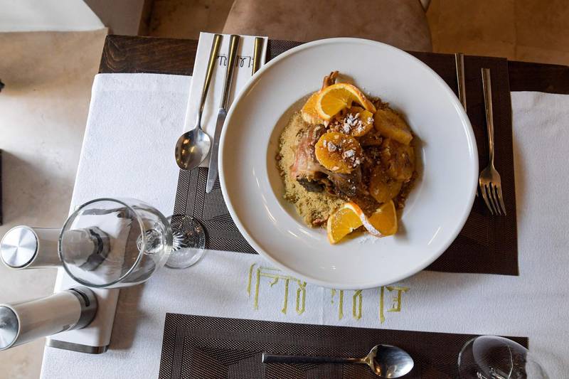 This picture taken on December 16, 2020 shows a view of a dish of lamb and orange couscous prepared by Tunisian chef Taieb Bouhadra, at a restaurant in the Medina (old town) of Tunisia's capital Tunis. Couscous, the Berber dish beloved across northern Africa's Maghreb and Sahel regions, has become a global foodie favourite now found on the shelves of organic supermarkets everywhere. Love it or hate it, but on December 16 the grain staple passed another culinary milestone when the UN cultural organisation honoured it as part of the world's intangible cultural heritage. / AFP / Fethi Belaid
