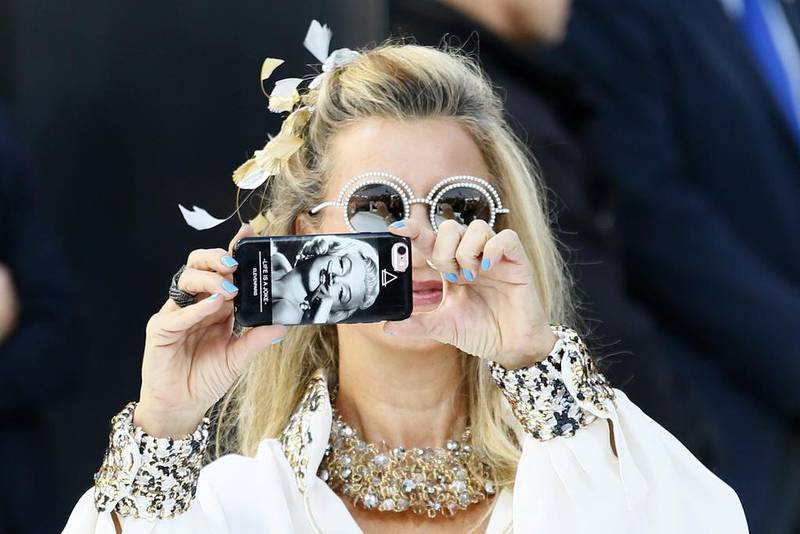 An unidentified guest takes pictures as she arrives at Chanel’s Spring-Summer 2017 ready-to-wear fashion collection in Paris. Francois Mori / AP
