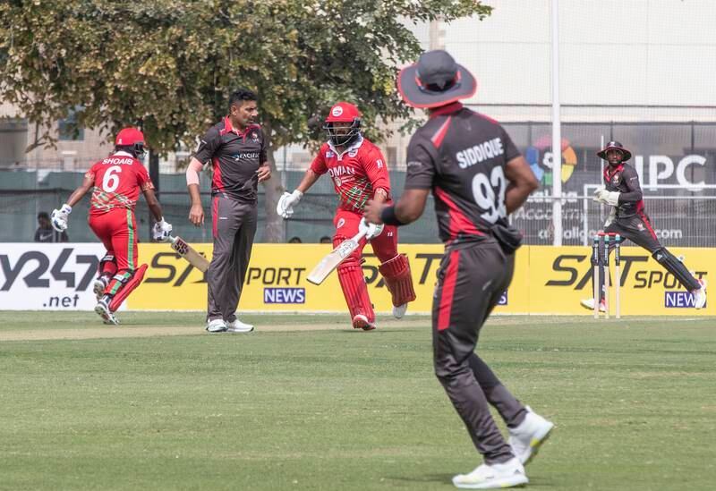 Oman players run between the wickets during the Cricket World Cup League 2 match at the ICC Academy in Dubai. 