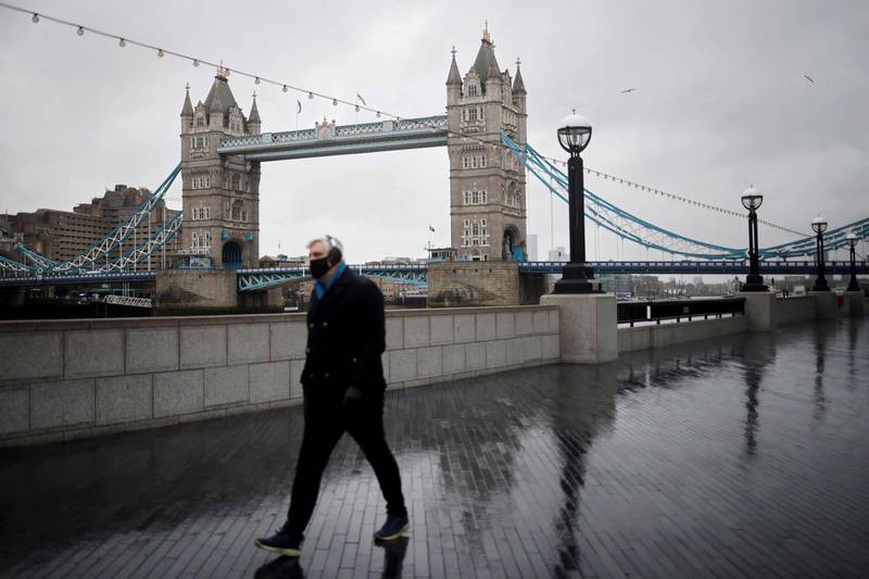 A man walks along the embankment as Britain enters a national lockdown in London on January 5, 2021. England's six-week lockdown, which began at midnight, emulates the first national coronavirus curbs in place from March to June -- but goes further than another instituted in November when schools remained open. 
 / AFP / Tolga Akmen
