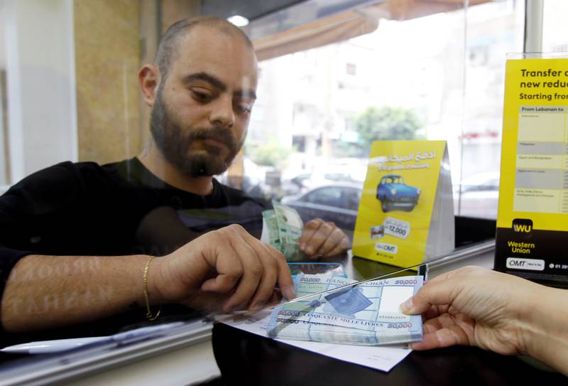 A man receives Lebanese pound notes at a money transfer centre in Beirut. The country's central bank has blamed currency speculation and the smuggling of US dollars outside Lebanon for the pound's depreciation. Reuters