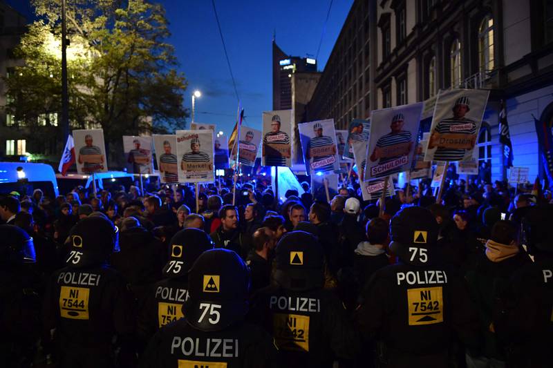 Anti-lockdown protesters in Leipzig last year, waving placards depicting politicians and health experts as guilty criminals. AFP