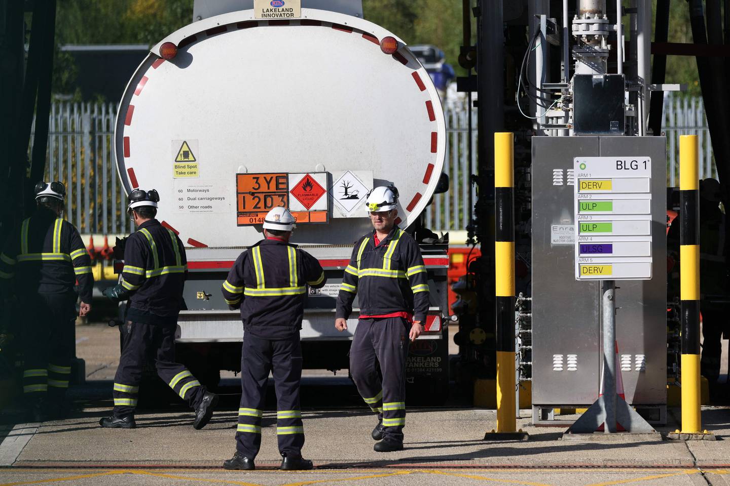 Technicians fill a tanker with petrol at an oil depot north of London. A shortage of HGV drivers pushed petrol firms into rationing deliveries. AFP