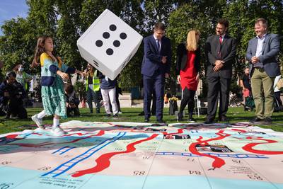 Gabriella throws a dice during a game of giant snakes and ladders in Parliament Square, to show the "ups and downs" of Ms Zaghari-Ratcliffe's case. PA