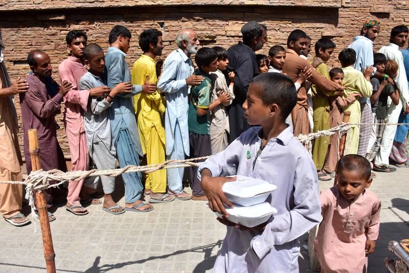 People affected by floods queuing to receive free food distributed by the Pakistan Red Crescent Society in Larkana. EPA