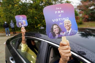 People hold fans with the images of US Democratic presidential candidate Joe Biden and vice presidential nominee Kamala Harris before a campaign event in Philadelphia, Pennsylvania, US. Reuters