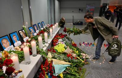 A man places flowers at a memorial for the victims of the Ukraine International Airlines Boeing 737-800 crash in the Iranian capital Tehran, at the Boryspil airport outside Kiev.  AFP