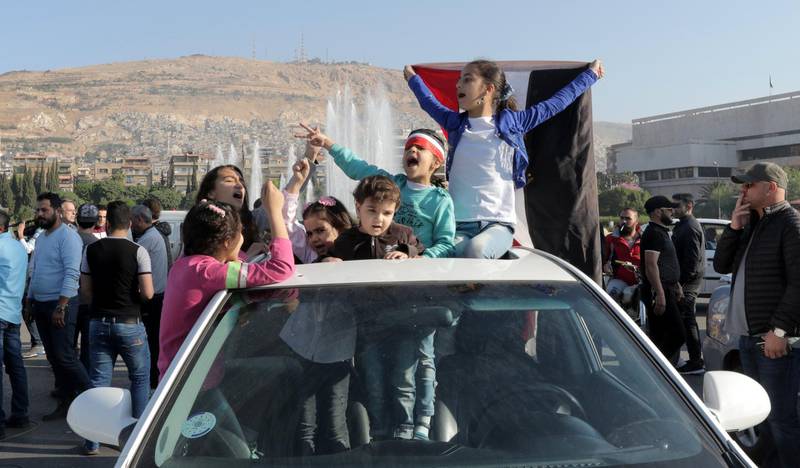 Syrian children wave a national flag during the gathering in Umayyad square. Youssef Badawi / EPA