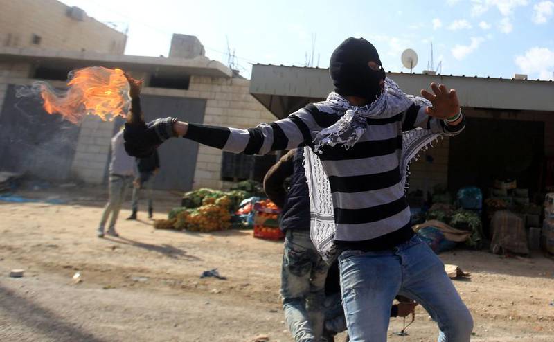 A demonstrator throws a Molotov cocktail towards Israeli security forces during clashes in the Palestinian town of Qabatiya, near Jenin in the north of the Israeli-occupied West Bank, on February 5, 2016. Jaafar Ashtiyeh / AFP