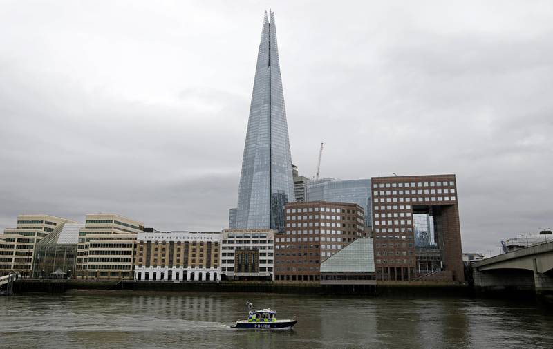 A police boat patrols the River Thames, near The Shard in London on March 30, 2020, as life in Britain continues during the nationwide lockdown to combat the novel coronavirus pandemic. - Life in locked-down Britain may not return to normal for six months or longer as it battles the coronavirus outbreak, a top health official warned on Sunday, as the death toll reached passed 1,200. (Photo by Tolga AKMEN / AFP)
