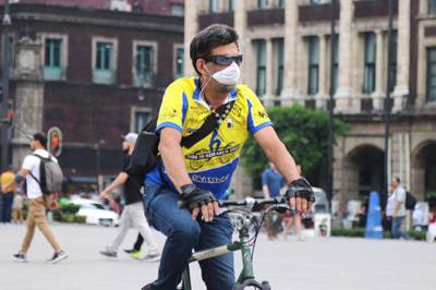 A man wears a mask while cycling around Mexico City.  EPA